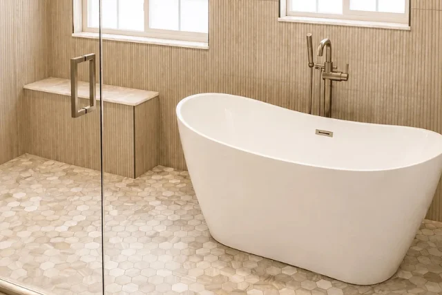 Modern bathroom remodel featuring a freestanding bathtub, glass shower, and elegant tile finishes